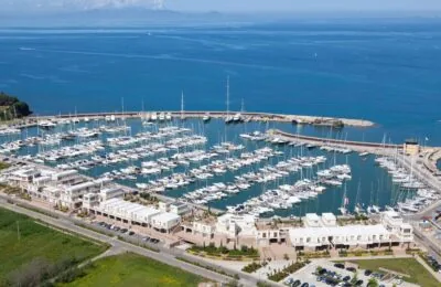 Aerial view of Marina Aero2 with numerous docked yachts and surrounding waterfront buildings along the coastline.