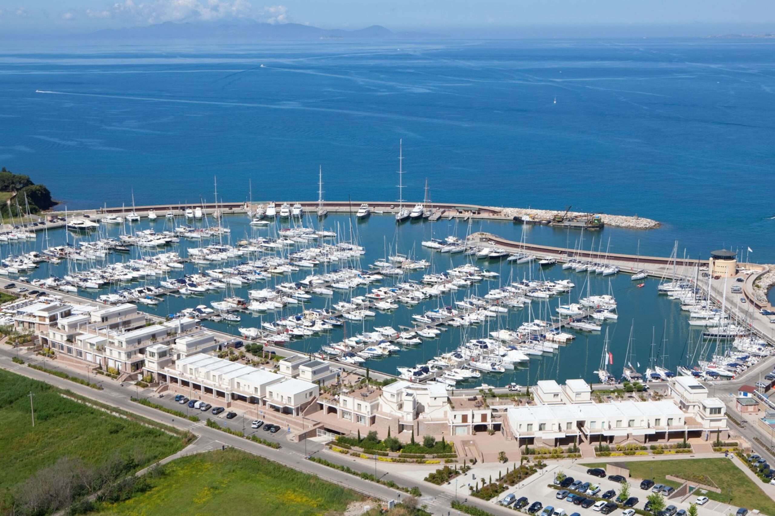 Aerial view of Marina Aero2 with numerous docked yachts and surrounding waterfront buildings along the coastline.