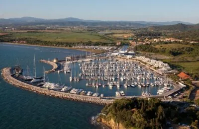 Aerial view of the Aero6 marina filled with numerous docked sailboats and yachts, surrounded by a breakwater and coastal landscape.