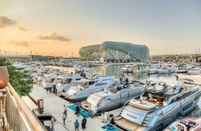Luxury yachts docked at Yas Marina with the futuristic Yas Viceroy hotel in the background at sunset.