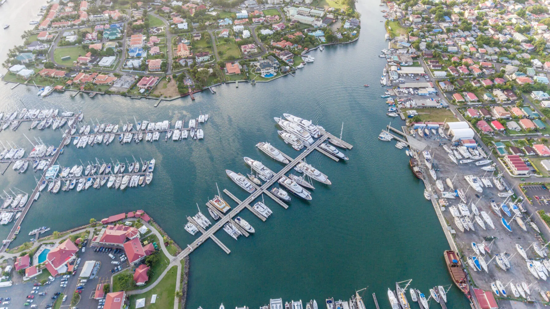 Aerial view of IGY Marina with numerous yachts and boats docked near a coastal residential area.