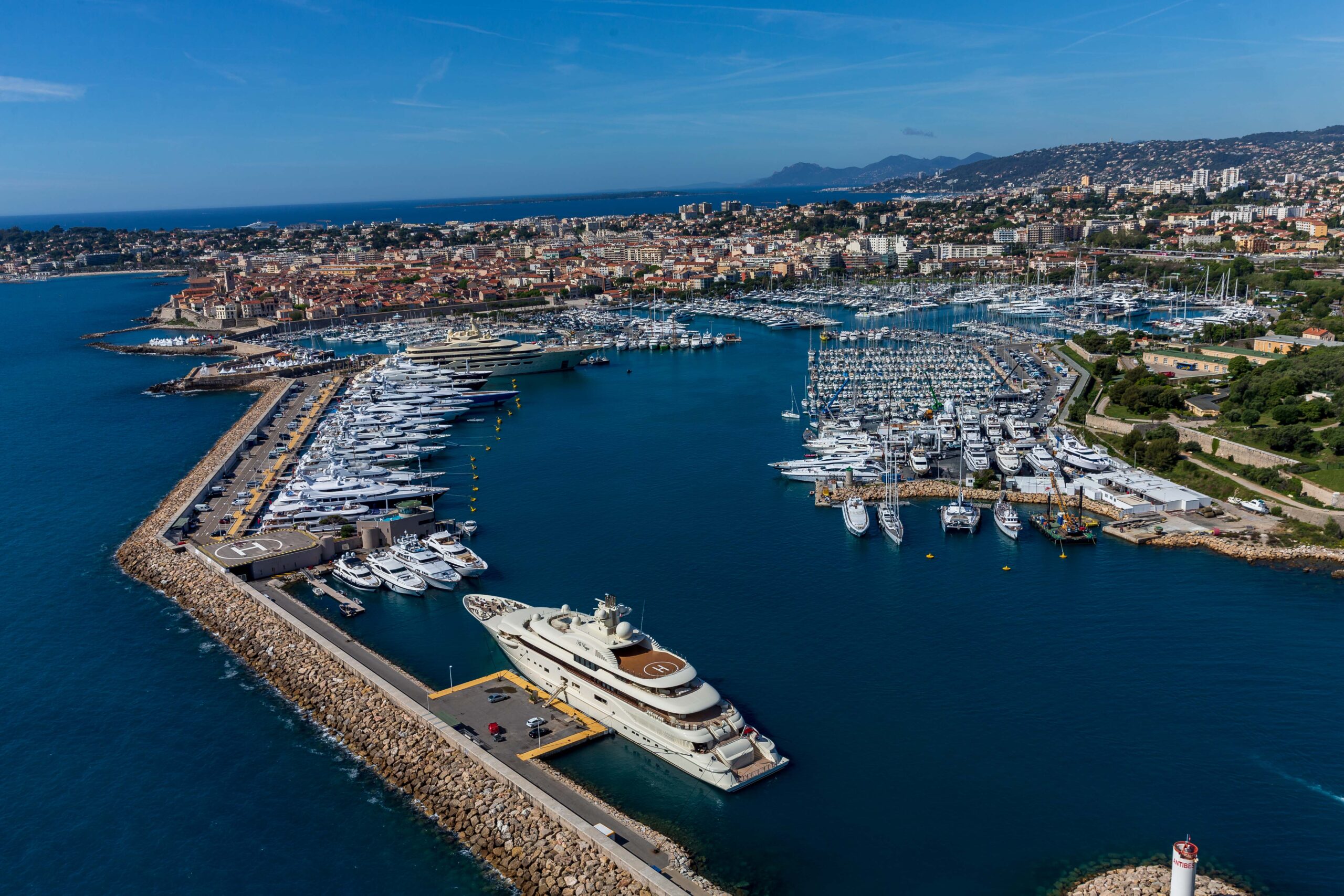 Aerial view of a large marina filled with yachts and boats in the coastal city of Cannes.