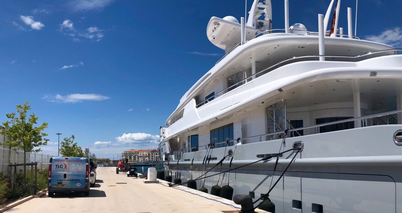 Luxury yacht Siren (05) docked at a marina on a sunny day.