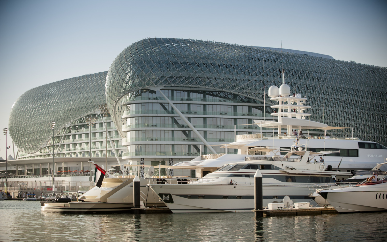 Luxury yachts docked in front of the futuristic Yas Hotel on Yas Island, Abu Dhabi.