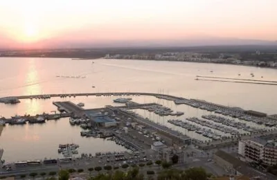 A marina filled with boats and yachts at sunset in the coastal city of Sant Carles de la Ràpita.