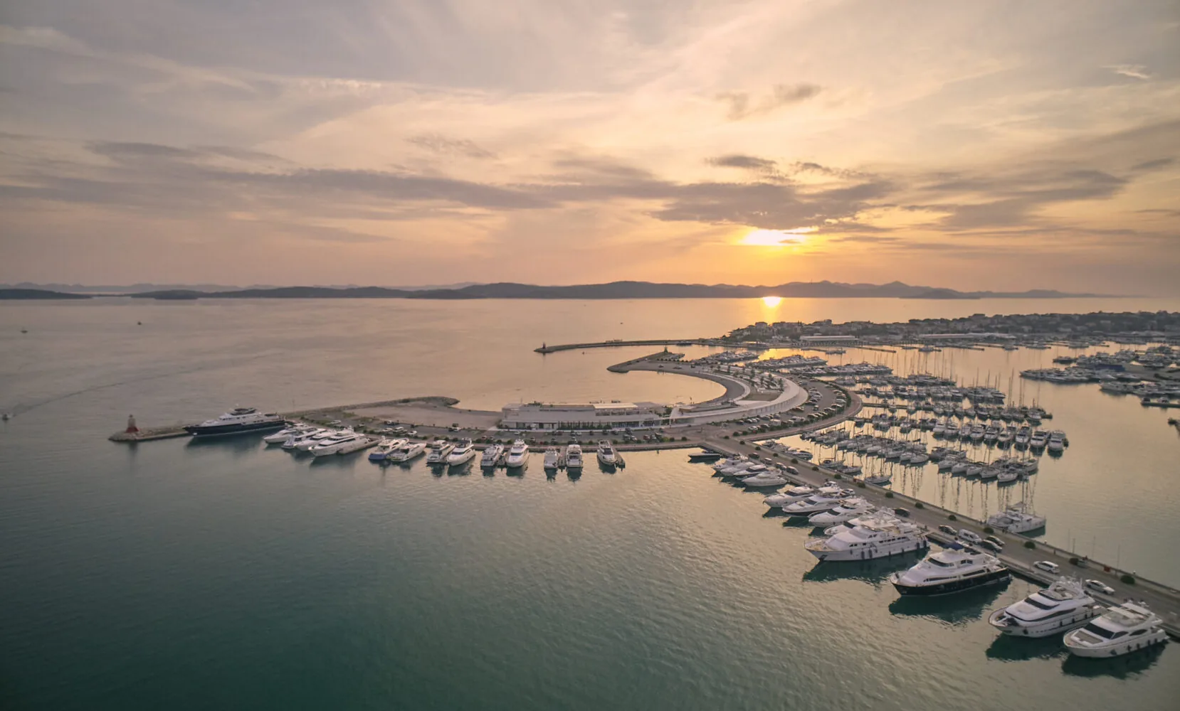 Luftaufnahme des mit Yachten gefüllten Yachthafens D-Marin Dalmacija bei Sonnenuntergang.