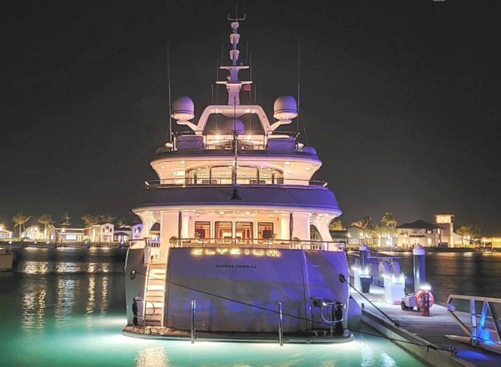 Luxury yacht "Elysium" docked at The Yacht Marina by Jalboot at night, illuminated by soft ambient lighting.