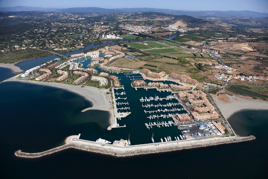 Aerial view of Puerto Sotogrande marina with surrounding residential buildings, beaches, and countryside.