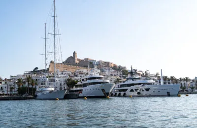 In einem Yachthafen vor Anker liegende Yachten, im Hintergrund sind die Altstadt von Ibiza und ihre Kathedrale zu sehen.