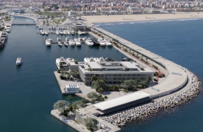 Luftaufnahme der Marina Port Valencia mit Yachten, die entlang der Küste inmitten einer pulsierenden Stadtlandschaft vor Anker liegen.